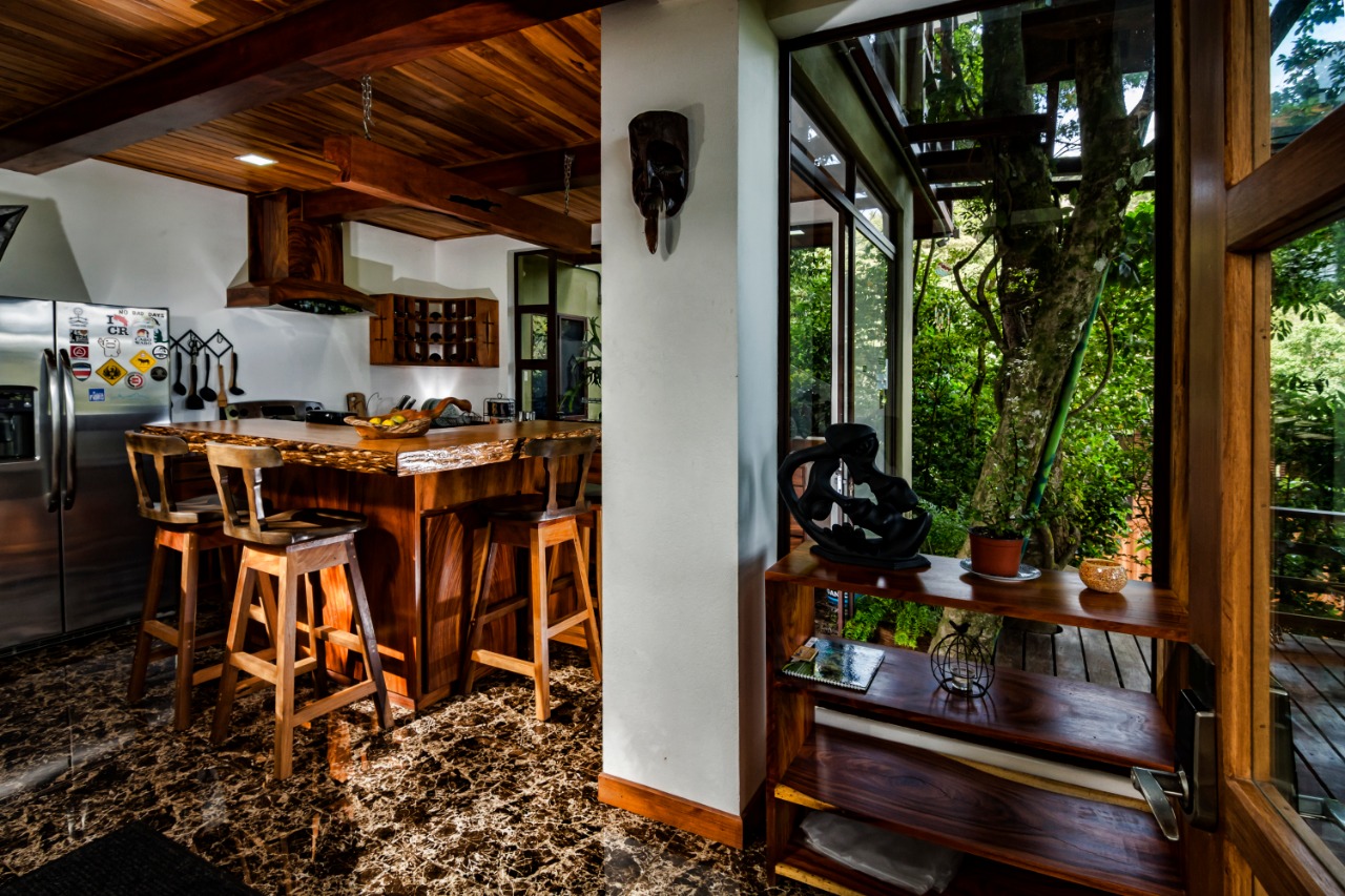 Cocina de Casa Ficus abierta al ventanal con vista al bosque nuboso