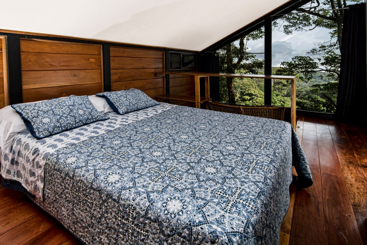 Cama queen en la segunda planta de la Guest House con vista al bosque nuboso