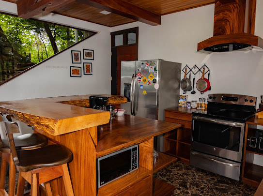 Cocina de Casa Ficus con refrigeradora, microondas y horno de acero inoxidable