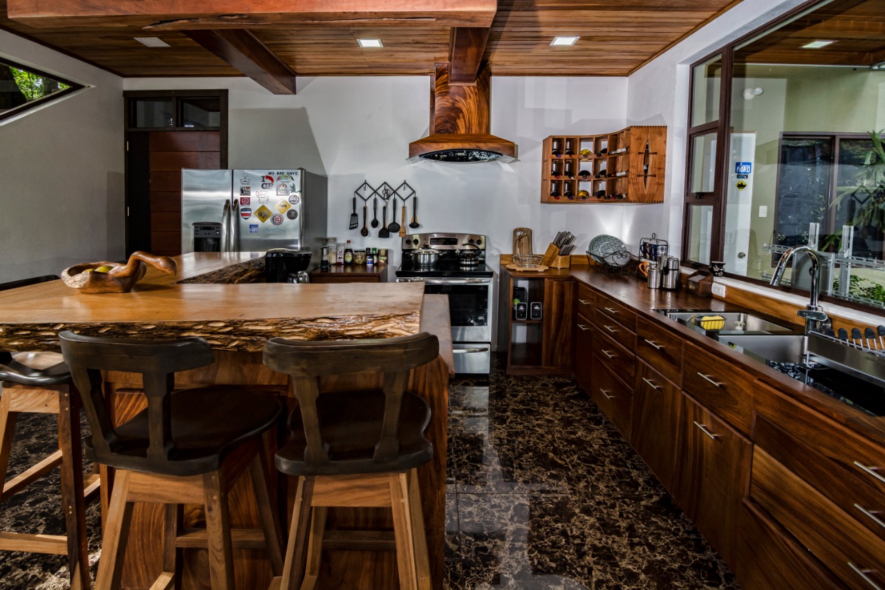Cocina de Casa Ficus con cocina de acero inoxidable, campana de madera y cava de vinos