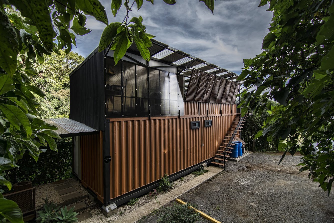 Exterior del Studio Maracuyá, estructura de contenedor y madera rodeada de vegetación en Monteverde